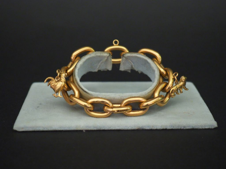Bracelet articulé en or jaune, maille forçat, à décor de deux pendeloq