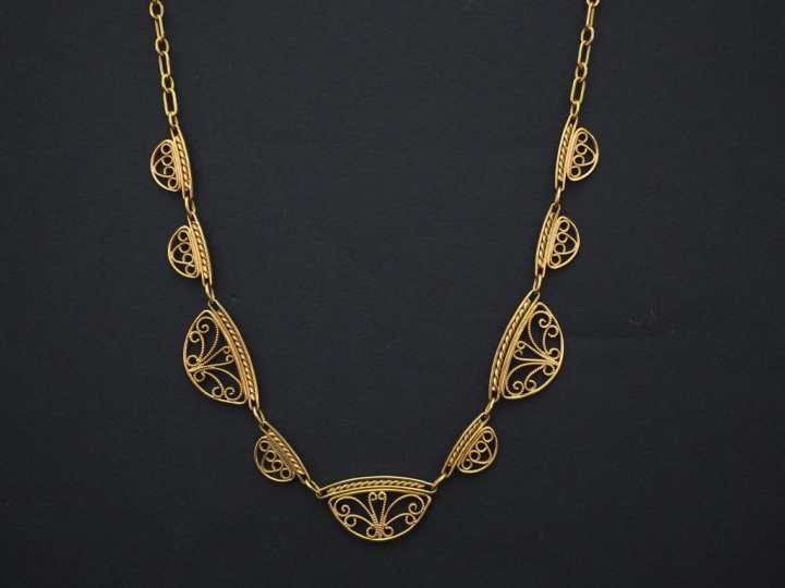 Collier en or jaune, maille forçat, à décor de neuf maillons filigrané