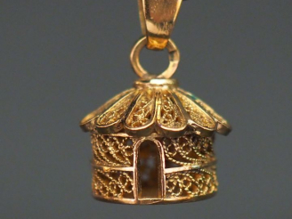 Vente aux enchères Pendentif en or jaune en forme de case, à décor de filigranes. H. 1,1 