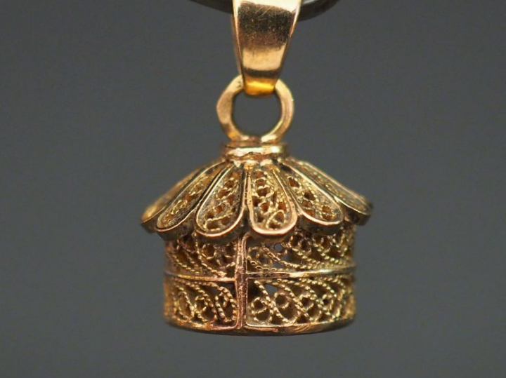 Pendentif en or jaune en forme de case, à décor de filigranes. H. 1,1 