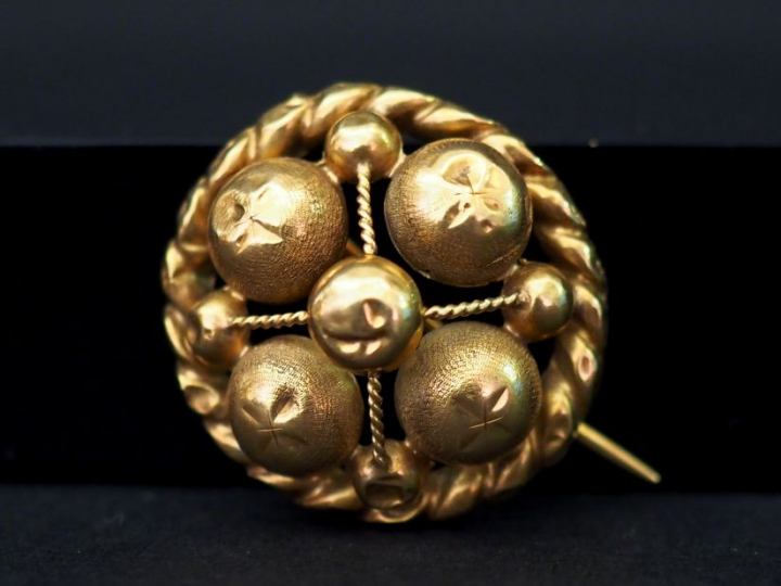 Broche ronde en or jaune, à décor ajouré de boules. Diam. 2,5 cm Poids