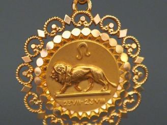 Vente aux enchères 	Pendentif circulaire en or jaune, à décor d’un lion, à décor ajouré. 