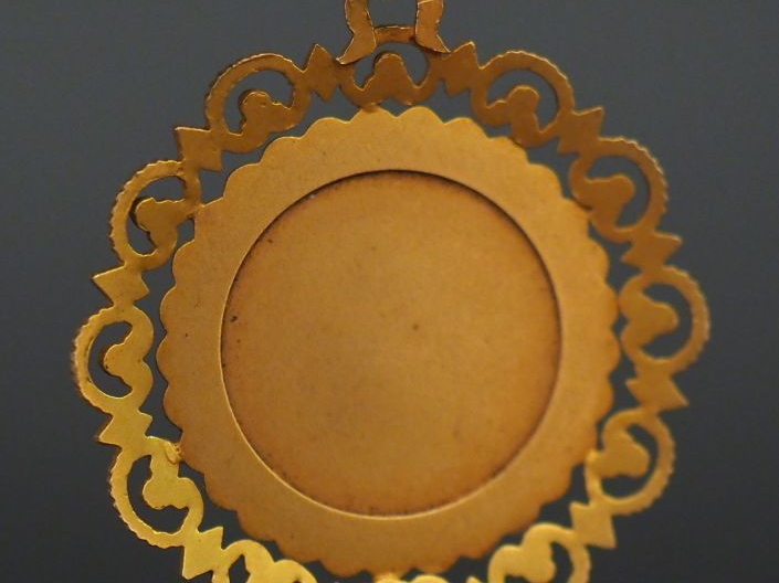 	Pendentif circulaire en or jaune, à décor d’un lion, à décor ajouré. 