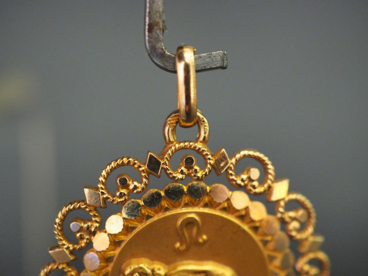 	Pendentif circulaire en or jaune, à décor d’un lion, à décor ajouré. 