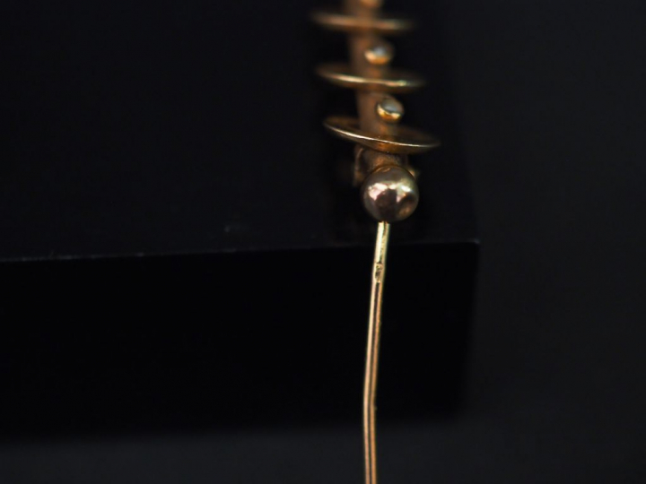 Broche barrette en or jaune, à décor de cercles entourant une tige cen