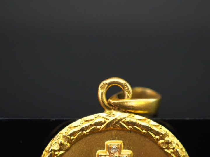 Médaille en or jaune, marquée « + qu’hier - que demain », sertie de ci