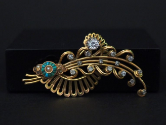 Vente aux enchères 	Broche en or jaune, en forme de tiges fleurie enrubannée, sertie de s