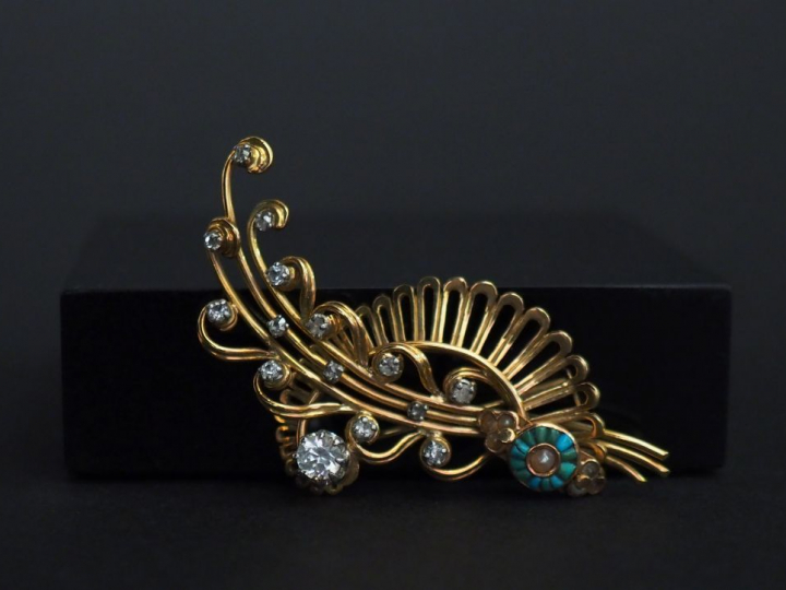 	Broche en or jaune, en forme de tiges fleurie enrubannée, sertie de s