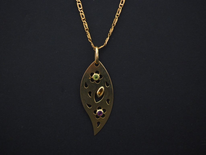 	Pendentif en or jaune en forme de feuille stylisée, serti de trois pe