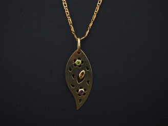 Vente aux enchères 	Pendentif en or jaune en forme de feuille stylisée, serti de trois pe