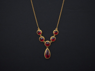 Vente aux enchères 	Collier en or jaune, à décor de six grenats dont un en forme de goutt