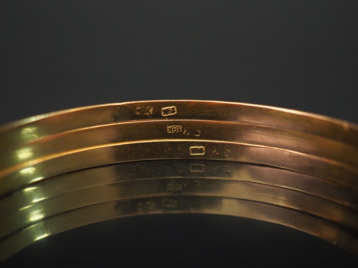 Trois bracelets jonc en or jaune, à décor de frises de fleurs, motifs 