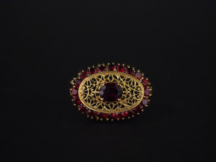 	Broche ovale en or jaune et grenats, à décor ajouré et filigrané d’ar