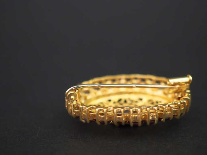 	Broche ovale en or jaune et grenats, à décor ajouré et filigrané d’ar