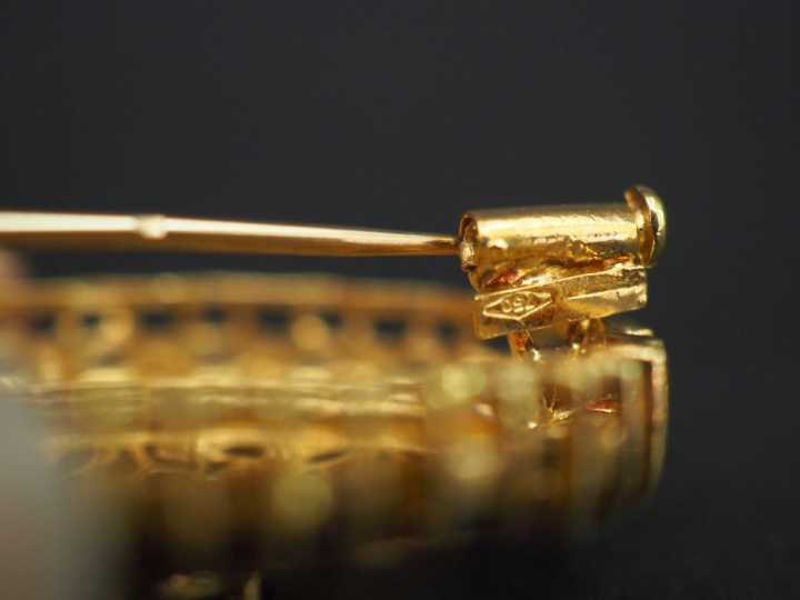 	Broche ovale en or jaune et grenats, à décor ajouré et filigrané d’ar