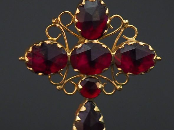 	Pendentif en forme de croix en or jaune, serti de six grenats, décor 