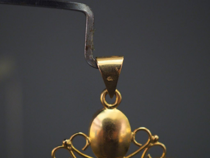 	Pendentif en forme de croix en or jaune, serti de six grenats, décor 