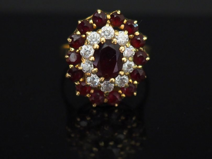 	Bague marguerite en or jaune, sertie en son centre d’un grenat entour