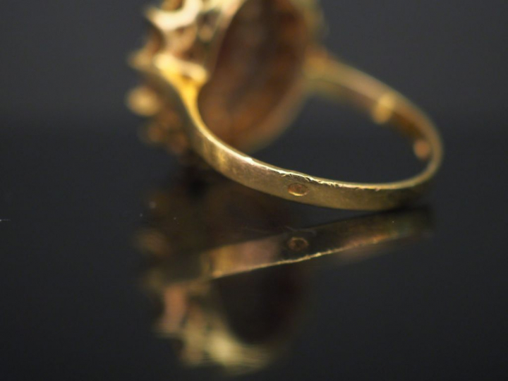 	Bague marguerite en or jaune, sertie en son centre d’un grenat entour