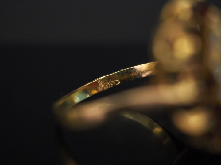 	Bague marguerite en or jaune, sertie en son centre d’un grenat entour
