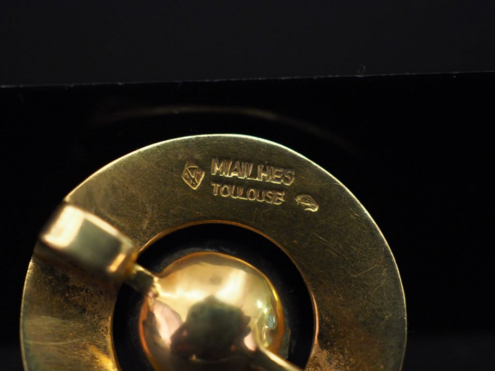 Pendentif rond en or jaune, sertie en son centre d’une perle grise. Di