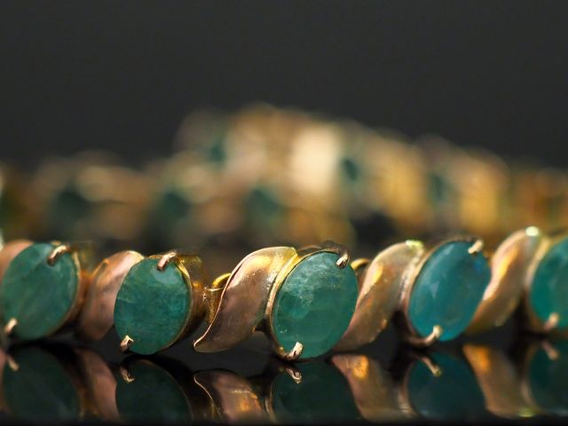 	Bracelet articulé en or jaune 14k, serti de dix-neuf émeraudes. Long.