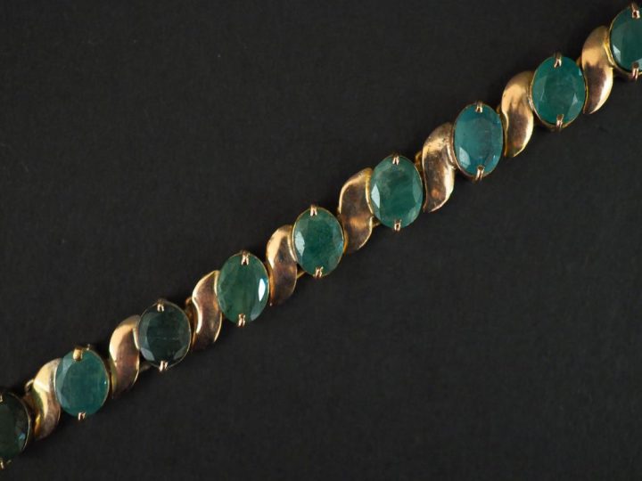 	Bracelet articulé en or jaune 14k, serti de dix-neuf émeraudes. Long.