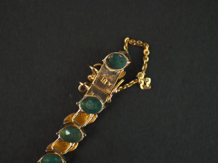 	Bracelet articulé en or jaune 14k, serti de dix-neuf émeraudes. Long.