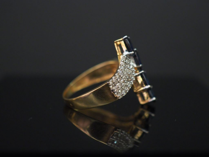 Bague moderne en or jaune, sertie en son centre de quatre saphirs.  Mo