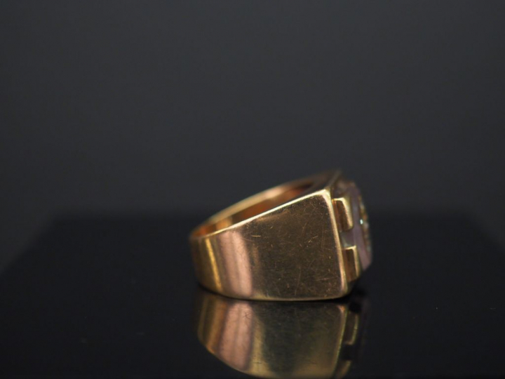 Bague chevalière en or jaune, sertie d’une améthyste (?), à décor d’un