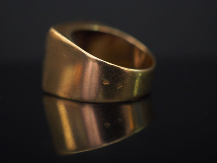 Bague chevalière en or jaune, sertie d’une améthyste (?), à décor d’un