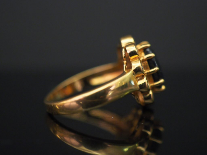 	Bague marguerite en or jaune, sertie en son centre d’un saphir entour