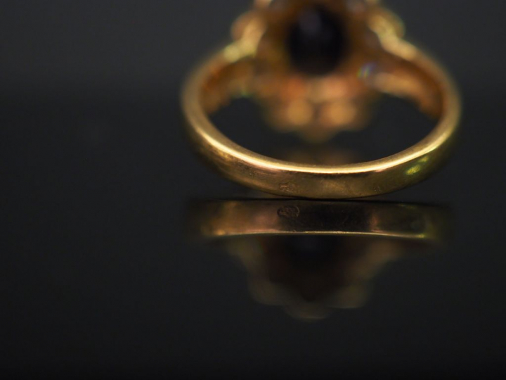 	Bague marguerite en or jaune, sertie en son centre d’un saphir entour