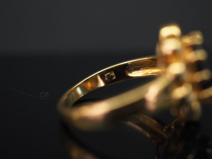 	Bague marguerite en or jaune, sertie en son centre d’un saphir entour