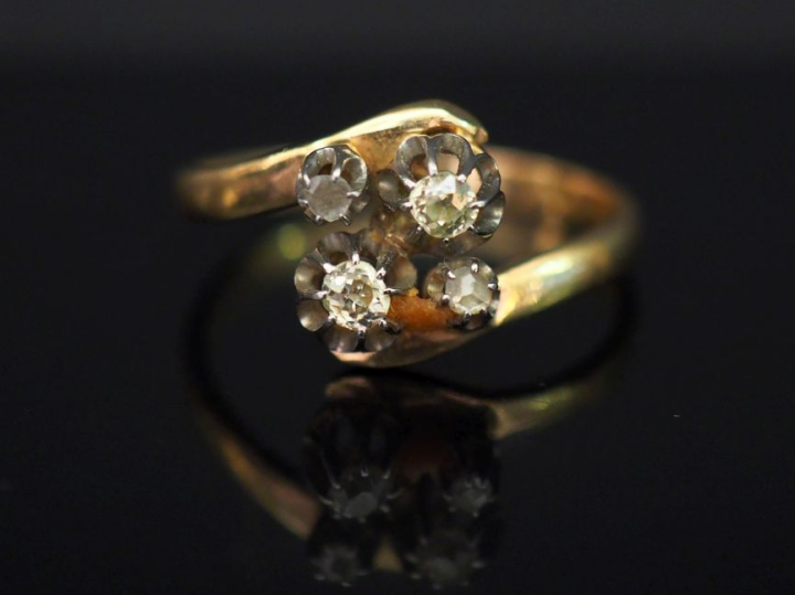 Bague en or jaune, sertie en son centre de quatre petits diamants tail