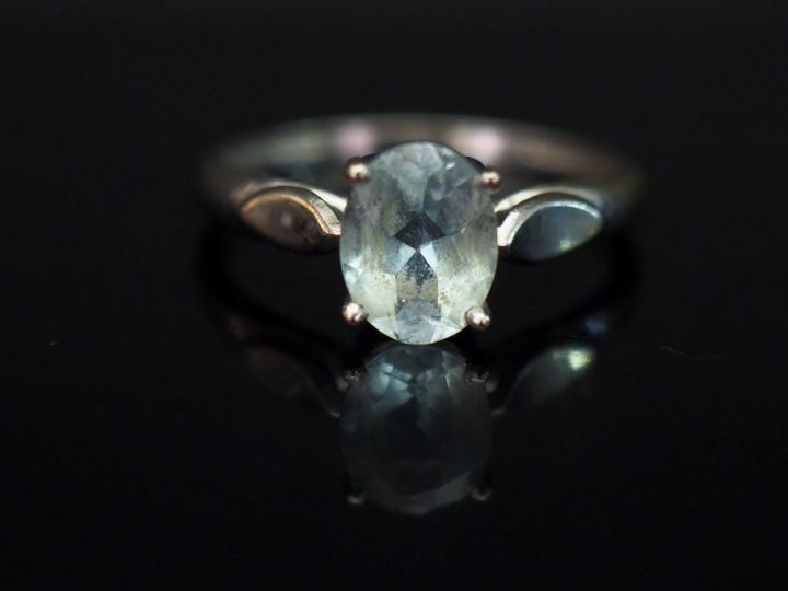 Bague en or blanc, sertie en son centre d’une pierre bleu ciel. TDD. 5