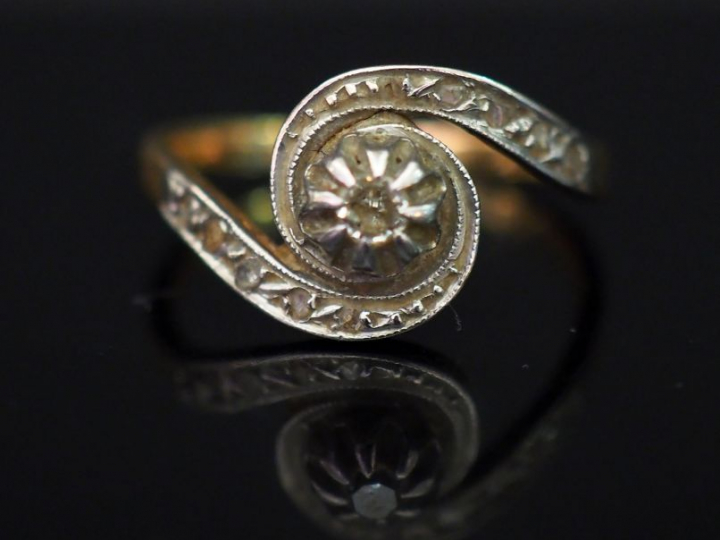 Bague tourbillon en or jaune, sertie en son centre d’un petit diamant.