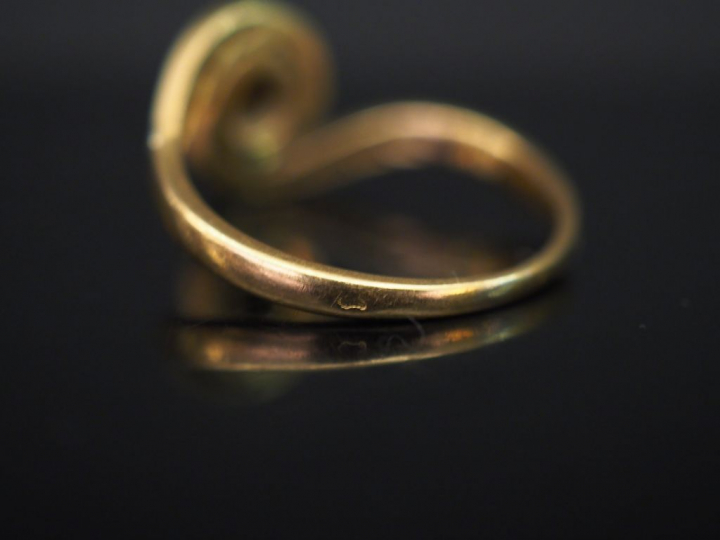 Bague tourbillon en or jaune, sertie en son centre d’un petit diamant.