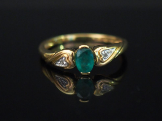 Vente aux enchères Bague en or jaune, sertie en son centre d’une émeraude épaulée de deux