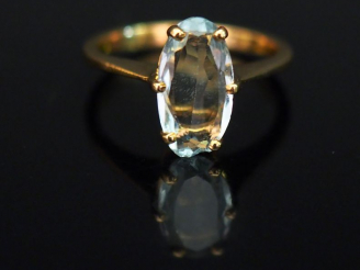 Vente aux enchères Bague en or jaune, sertie en son centre d’une pierre bleu ciel. TDD. 4