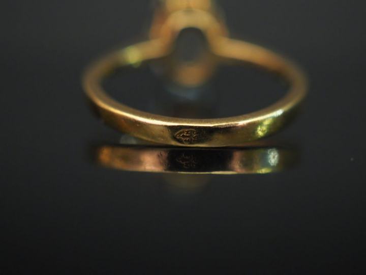 Bague en or jaune, sertie en son centre d’une pierre bleu ciel. TDD. 4