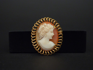 Vente aux enchères 	Broche/pendentif en or jaune, sertie en son centre d’un camée figuran