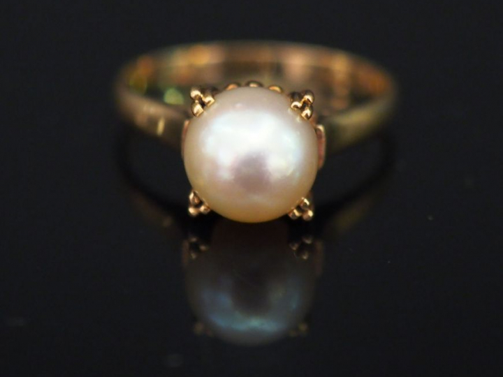 Bague en or jaune, sertie en son centre d’une perle blanche. TDD. 53 P