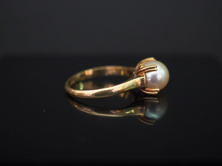 Bague en or jaune, sertie en son centre d’une perle blanche. TDD. 53 P