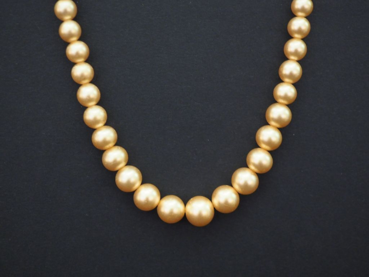 	Collier ras de cou trois rangs de perles. Un rang de perles grises ép