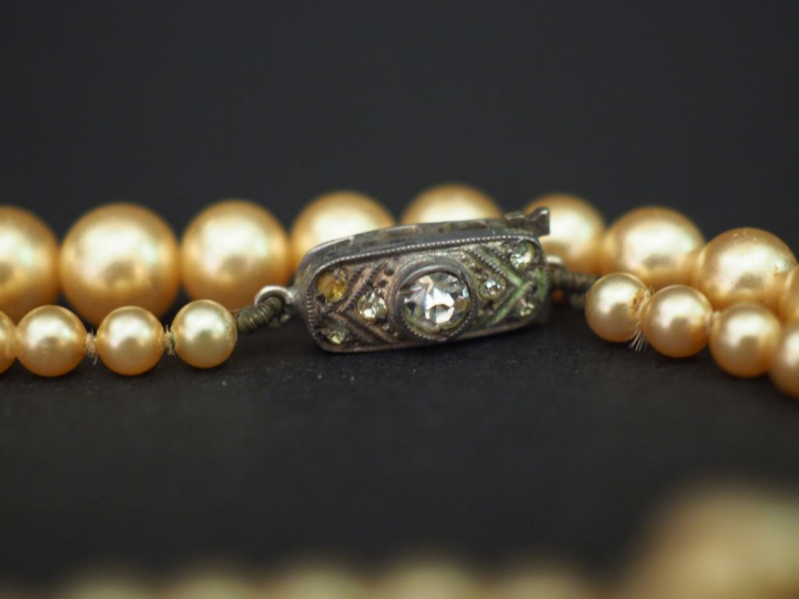 	Collier ras de cou trois rangs de perles. Un rang de perles grises ép