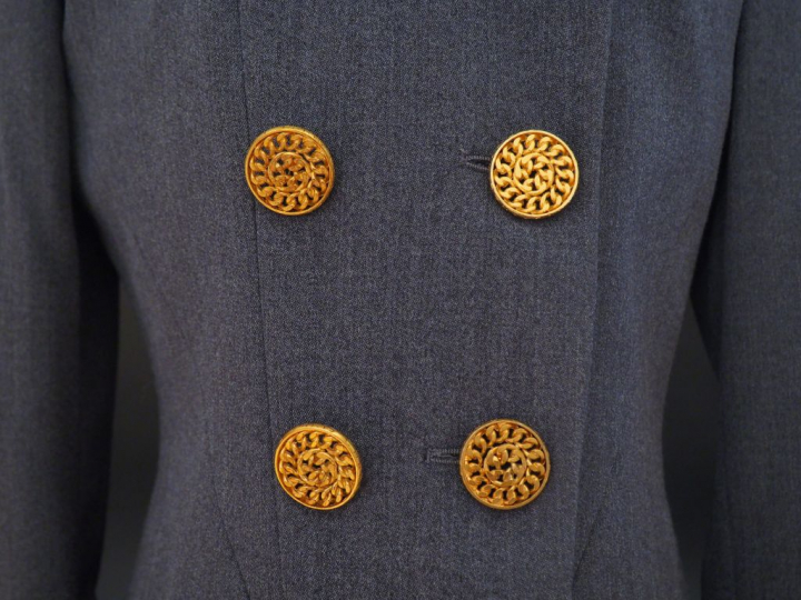 	CHANEL  Veste en laine grise, doublure en soie.  Deux rangs de six bo