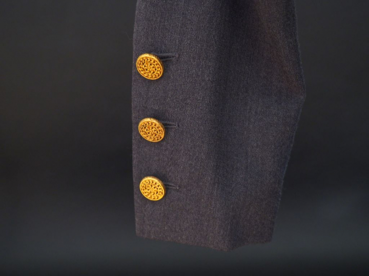 	CHANEL  Veste en laine grise, doublure en soie.  Deux rangs de six bo