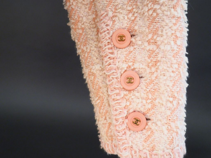 CHANEL Veste courte à col dans les tons roses et écru. Deux poches pla