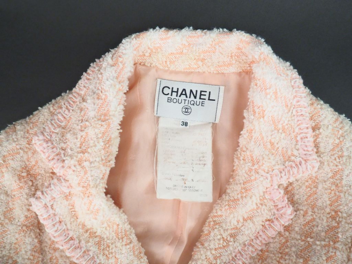 CHANEL Veste courte à col dans les tons roses et écru. Deux poches pla